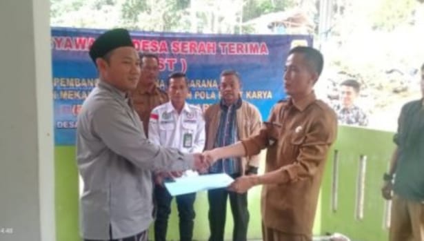 Kasi Ekbang Kecamatan, Dadan, serahkan Surat Keputusan (SK) pemeliharaan bangunan kepada Kepala Desa Sukasenang, Surdi