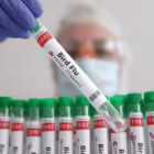 A person holds a test tube labelled 