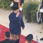Prabowo mengenakan baju adat Betawi berwarna biru tua dan peci hitam